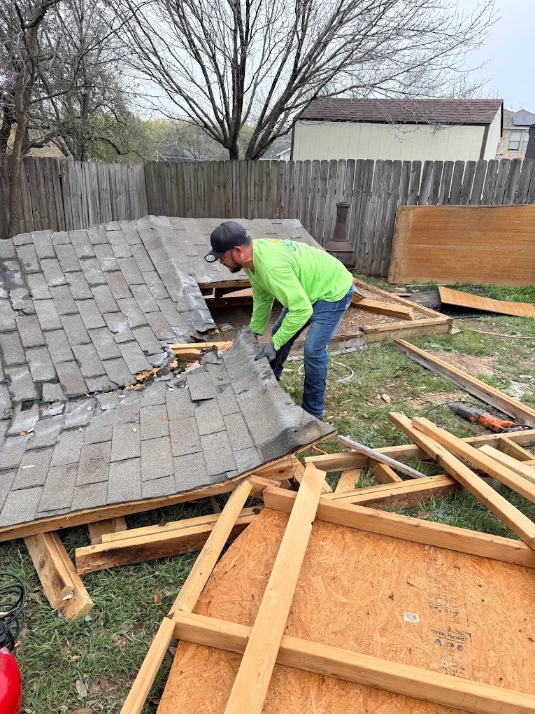 Crew tearing down a shed roof for haul-away